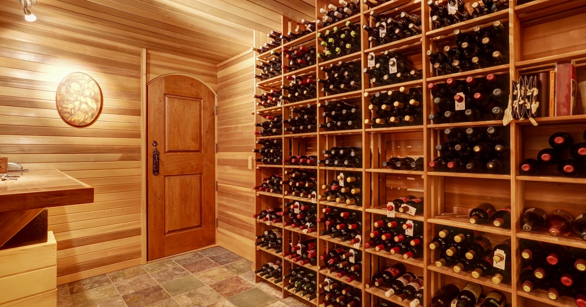 Several wooden crates are stacked on top of each other. Each crate holds several bottles of wine, creating a collection.
