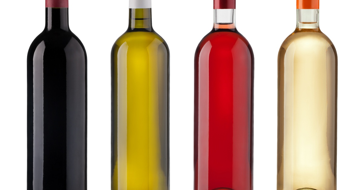 Four bottles of wine sit side by side on a white background. There are two clear bottles, one black and one green.